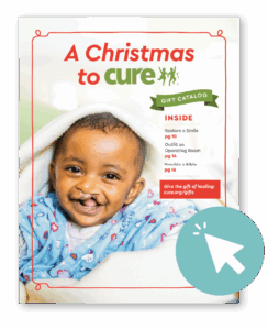 Cover of the "A Christmas to CURE" gift catalog, featuring a smiling baby with a cleft lip, a table of contents, and a click cursor overlay.