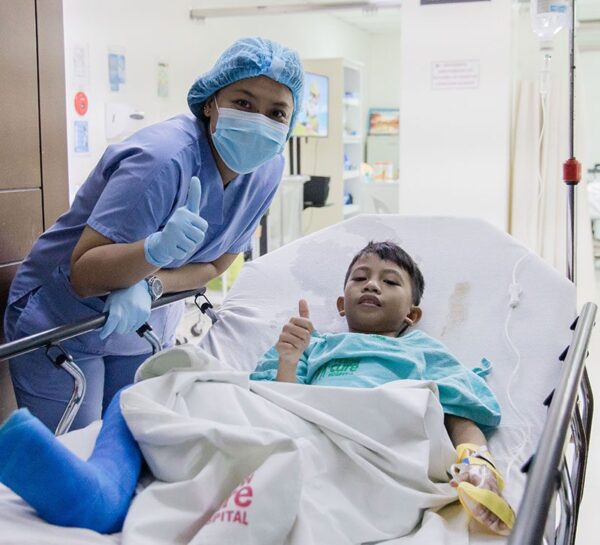 Boy in hospital bed with nurse