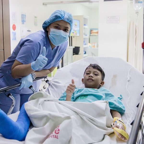 Boy in hospital bed with nurse