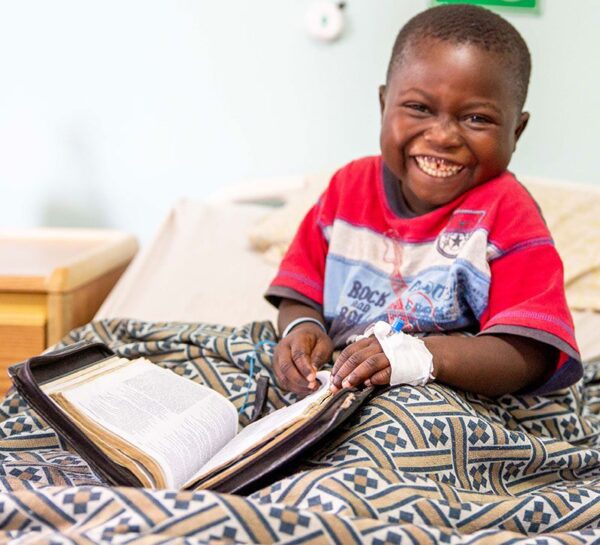 child laughing while reading the bible