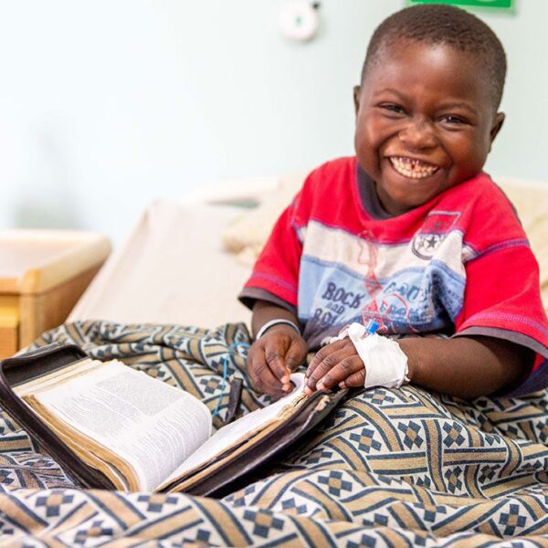 child laughing while reading the bible